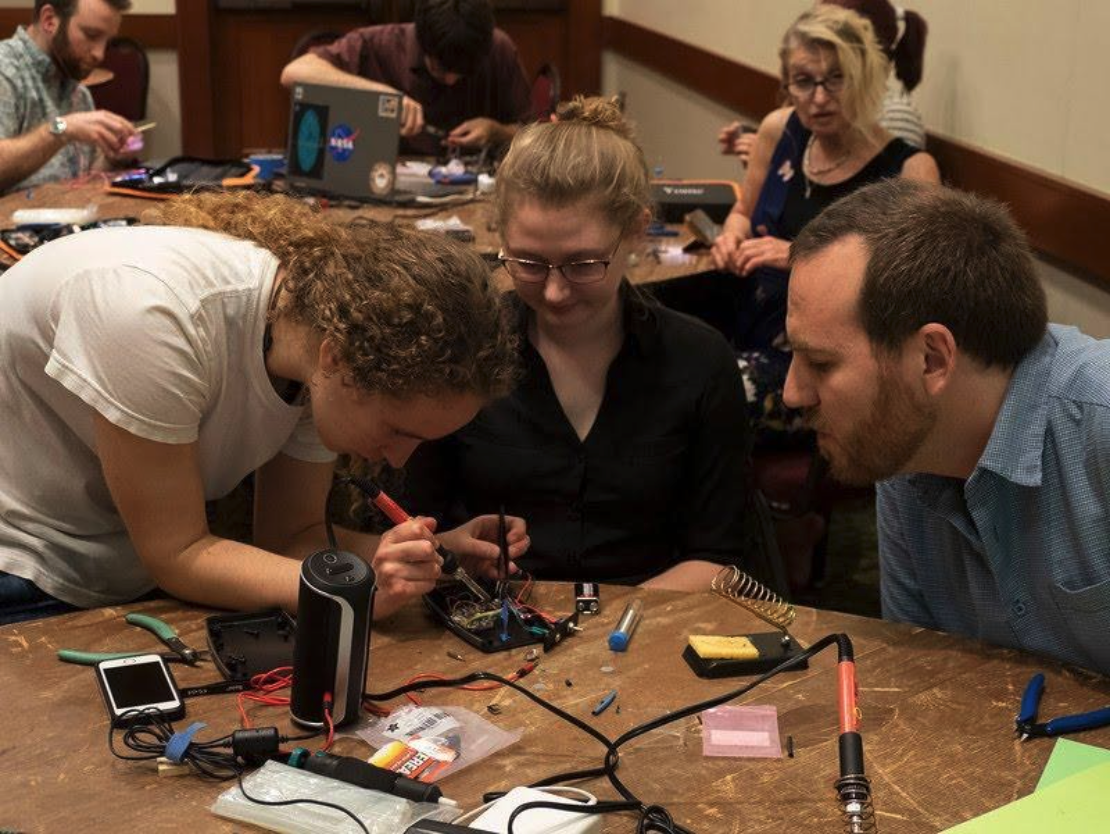 Soléy Hyman (left) guides LightSound participants on how to solder the components of the LightSound during an AAS #235 workshop session. 