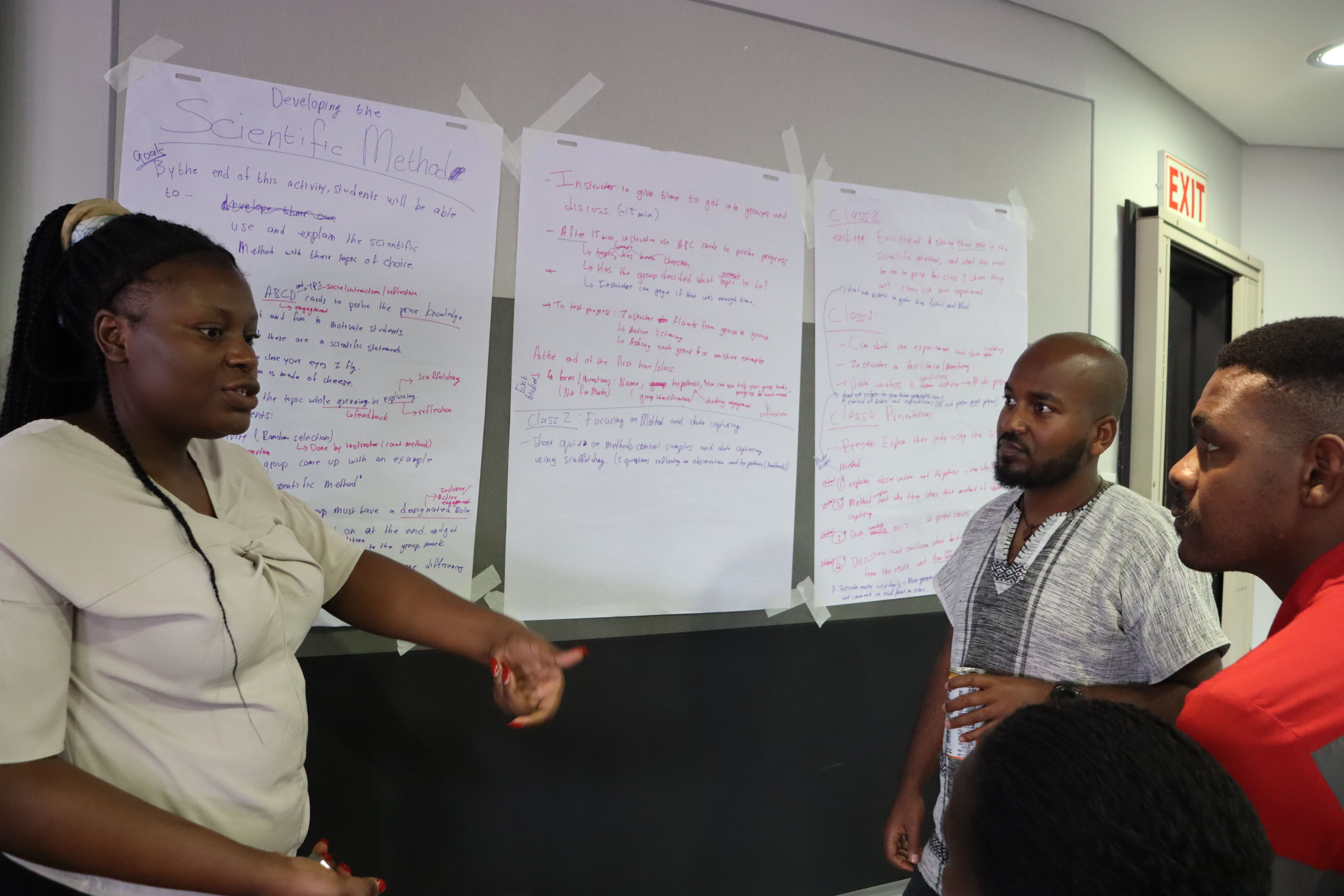 Josephine Chishala (Botswana International University of Science and Technology) explains her group's active learning activity design to Lealem Kinfe Alula (Ethiopian Space Science Society) and Dr. Eliab Malefahlo (University of South Africa)